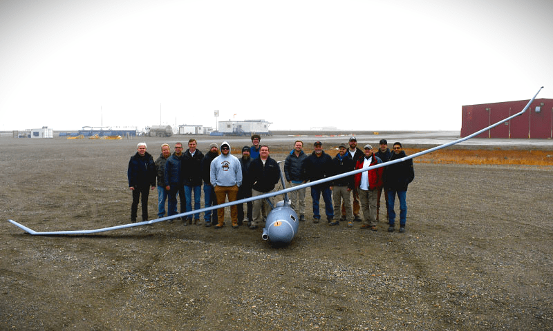 A team of researchers next to an unmanned aerial vehicle (UAV)