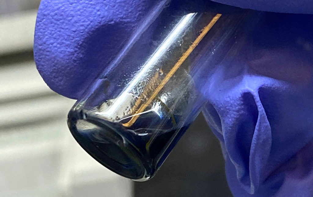 The purple/blue solution in this vial contains crystals of the berkelocene “sandwich.” (Credit: Alyssa Gaiser/Berkeley Lab)