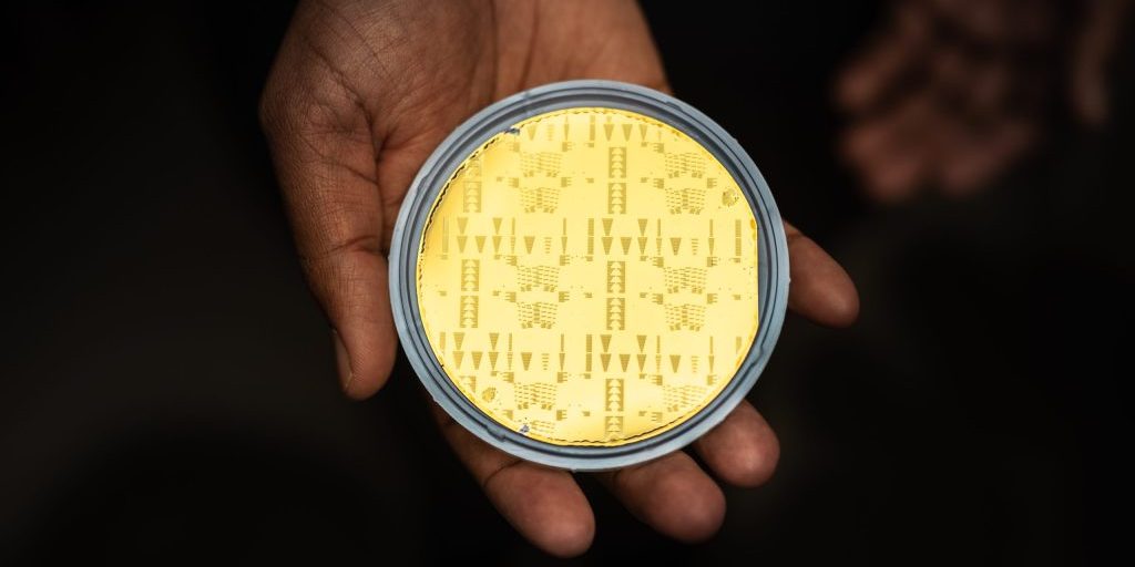 Ashok Kodigala holds a gold-plated wafer filled with thousands of minute lasers made at  Sandia National Laboratories MESA facility (photo by Craig Fritz, SNL).