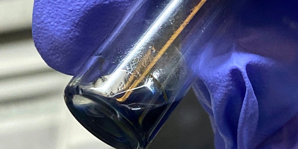 The purple/blue solution in this vial contains crystals of the berkelocene “sandwich.” (Credit: Alyssa Gaiser/Berkeley Lab)