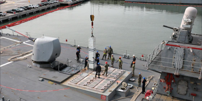 Sailors assigned to the Arleigh Burke-class destroyer USS Porter (DDG 78) and Navy Expeditionary Logistics Support Group’s Expeditionary Reload Team stow simulated ordnance in the ship's MK 71 Vertical Launch System (VLS) during a VLS re-arm demonstration held pier-side on Naval Station Norfolk, August 3 (U.S. Navy).